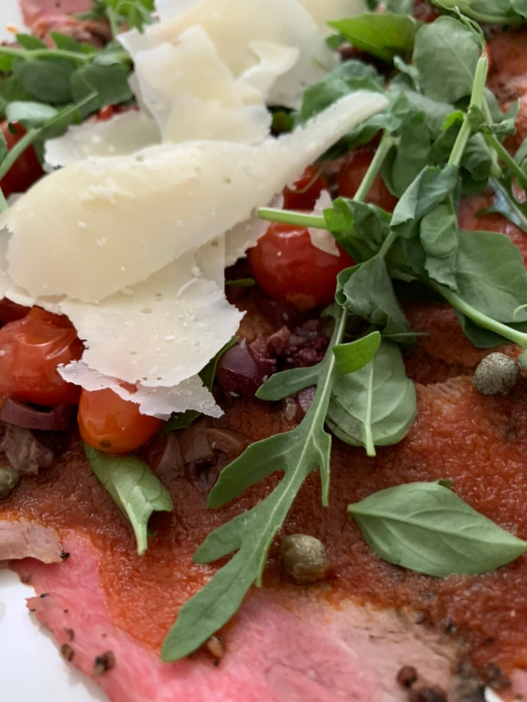 Carpaccio de roast beef de filete con vinagreta de jitomate deshidratado, alacaparra y kalamata