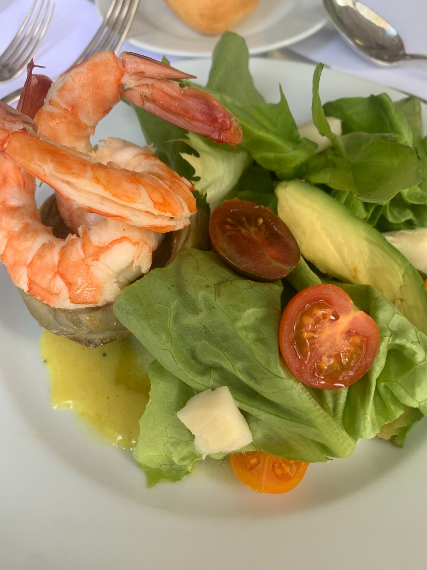 Corazón de alcachofa relleno de camarones en escabeche y mezcla de lechugas, palmito, jitomates cherry y aguacate a la vinagreta