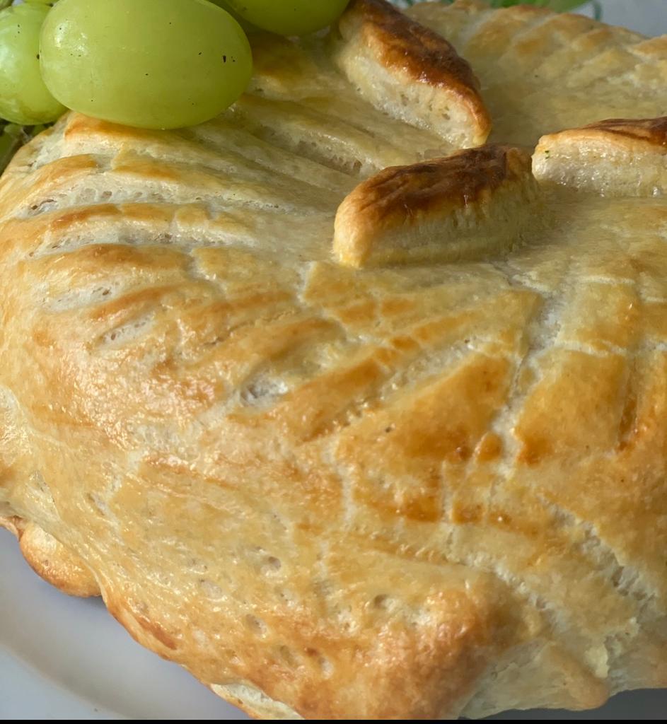 Delicioso queso brie horneado en pasta de hojaldre, listo para disfrutar.