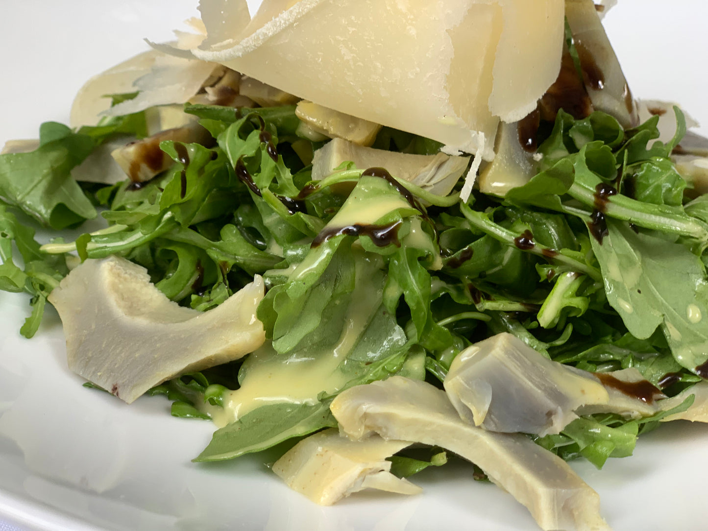 Combinación de la arúgula, corazón de alcachofa y láminas de parmesano grana padano aderezada con vinagreta de limón la cual da a esta ensalada un toque muy fresco, puede servirse como entrada o acompañando algún plato fuerte. La porción es para 6 personas.