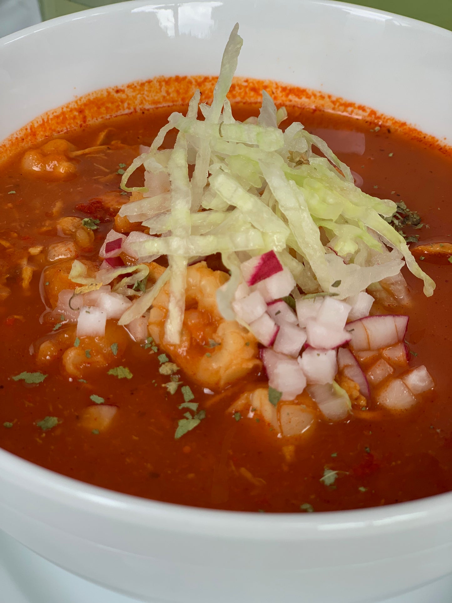 Tradicional pozole rojo de pollo con elote. La porción incluye un litro, ideal para tres personas.